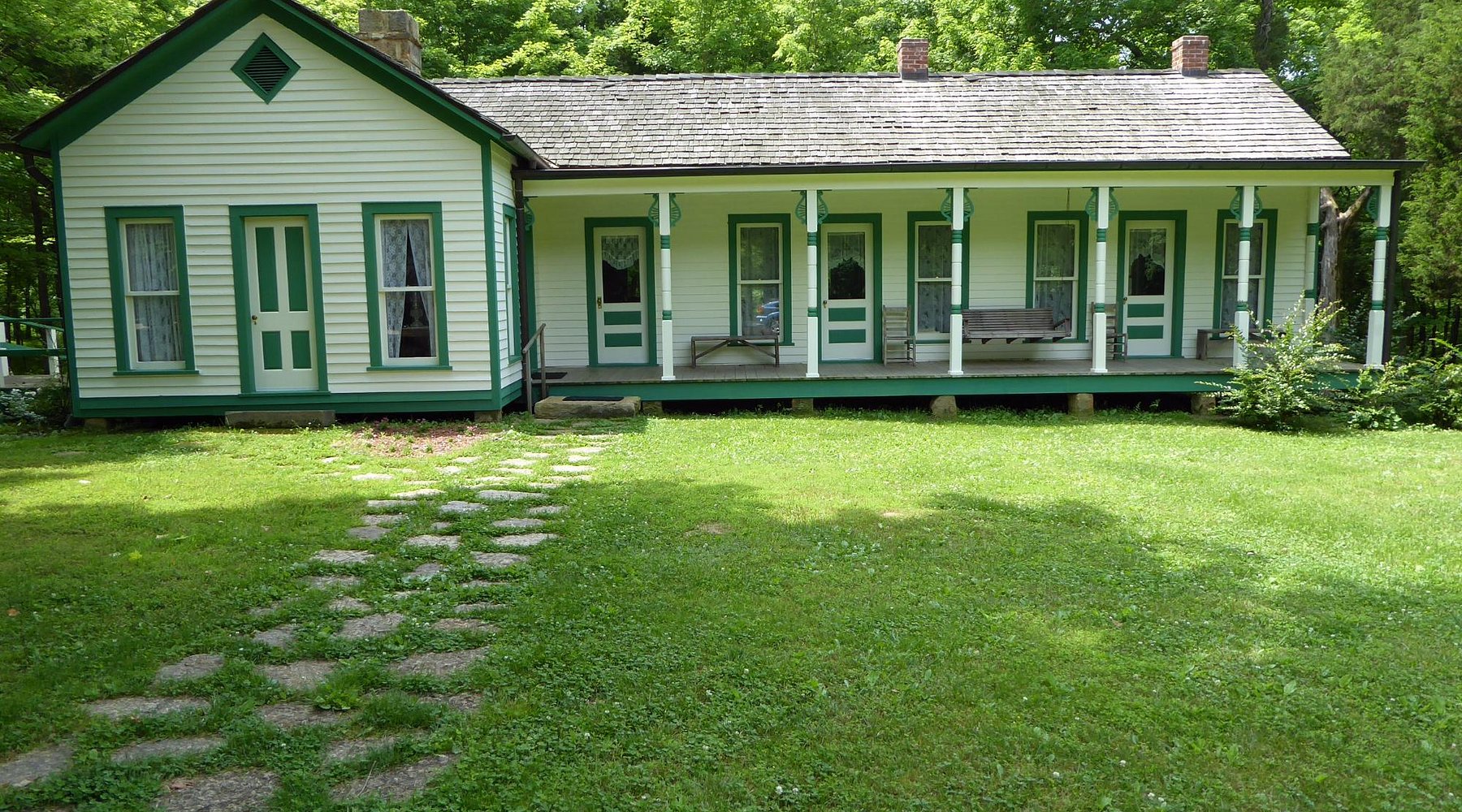 A historic home painted green and white.