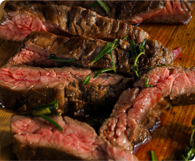 Macro shot of juicy cuts of rare steak seasoned with rosemary